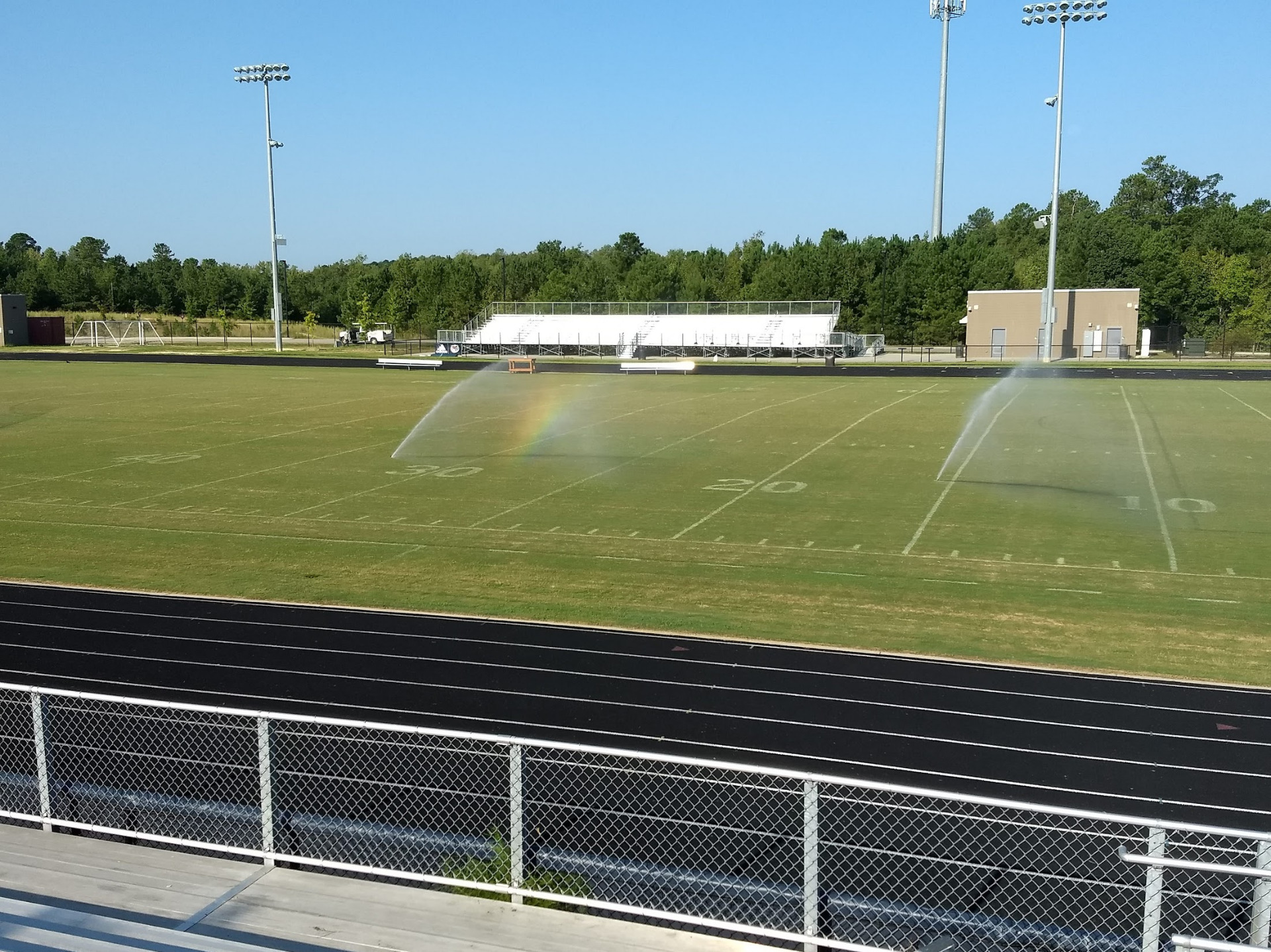 Sprinklers spray the empty AFHS football field